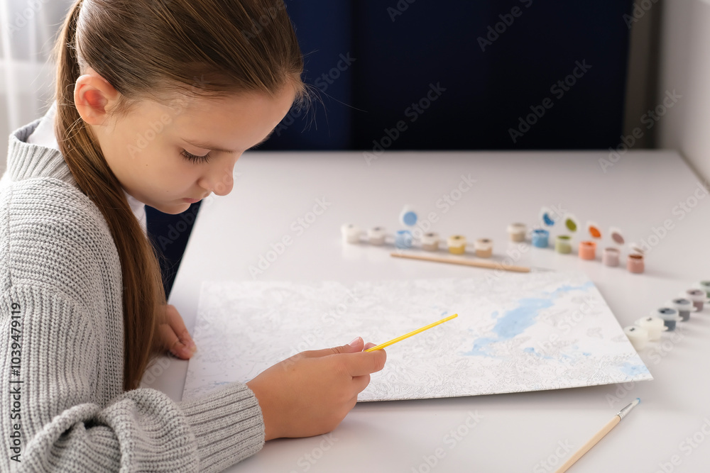 Girl is happy to paint with brush by numbers on the canvas. Painting by numbers. Creative hobby. Painting for beginners. Concept of a hobby. Selective focus. Girl is happy to paint with brush by numbers on the canvas. Painting by numbers. Creative hobby. Painting for beginners. Concept of a hobby. Selective focus.