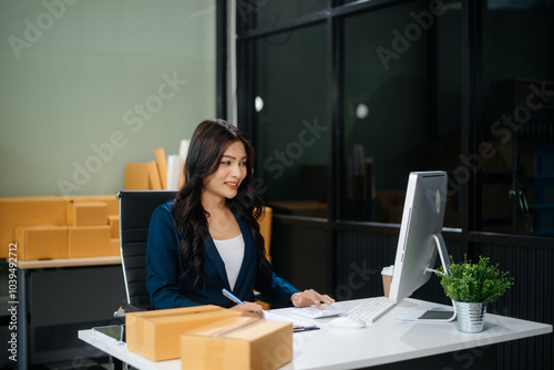 Businesswoman handling packaging and logistics in a modern workspace, managing e-commerce orders efficiently