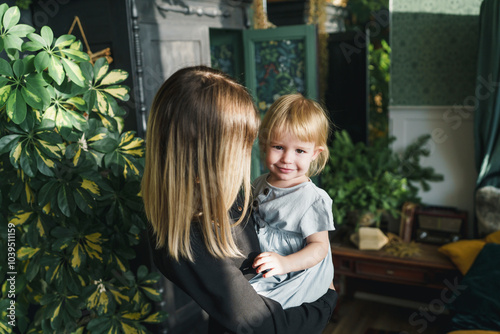 Mother carrying smiling daughter on Christmas at home