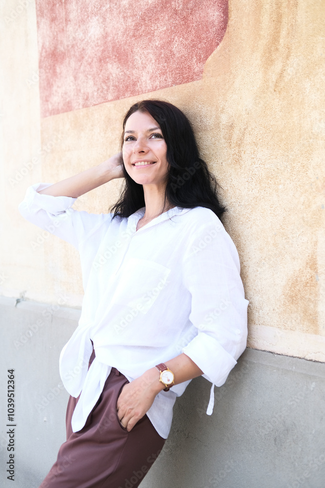 Smiling beautiful woman leaning on wall Smiling beautiful woman leaning on wall