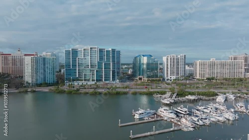 Aerial forward dolly over Marina Jack toward downtown Sarasota roundabout, with overcast skies. Filmed day after Hurricane Milton, showing dock and boats photo