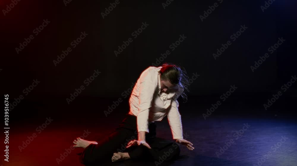 Modern choreography and theatre performance, woman sitting on floor on stage. Emotional lady moving and dancing contemporary style dance, show or rehearsal, talented female dancer or actress Modern choreography and theatre performance, woman sitting on floor on stage. Emotional lady moving and dancing contemporary style dance, show or rehearsal, talented female dancer or actress