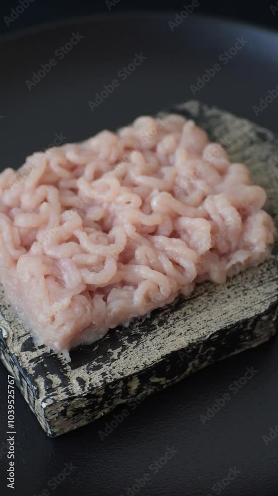 Fresh raw chicken mince with salt, spices and herbs on a dark concrete background Fresh raw chicken mince with salt, spices and herbs on a dark concrete background