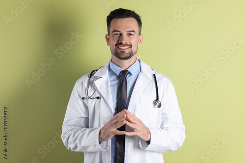 Smiling doctor with stethoscope on olive background