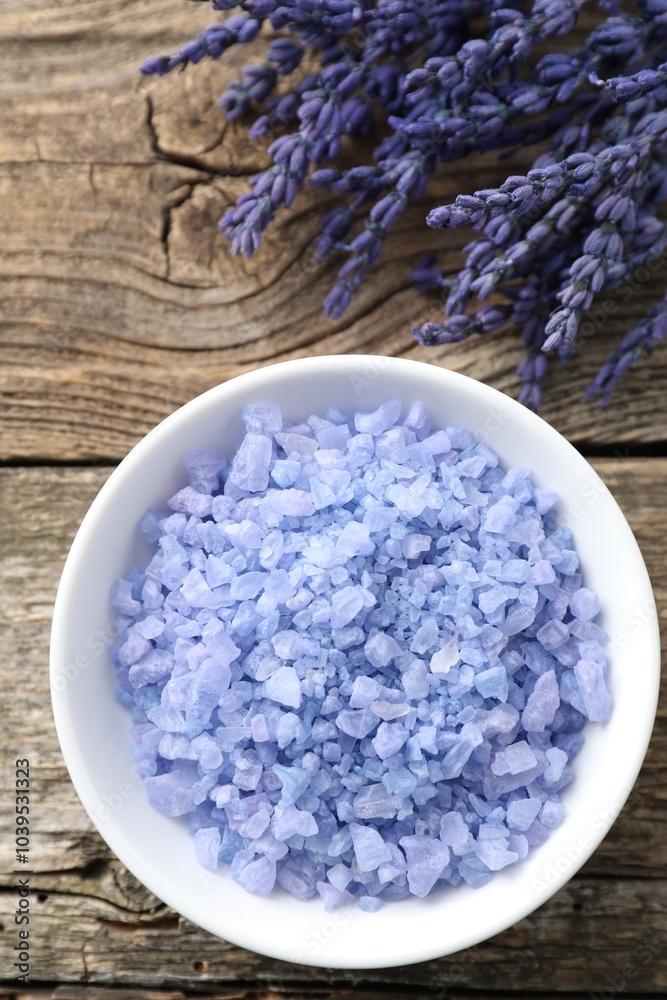 Natural sea salt in bowl and lavender on wooden table, top view Natural sea salt in bowl and lavender on wooden table, top view