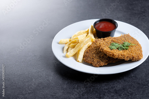 Cachopo, Traditional food in Asturias, Spain. Breaded fillet meat on black slate background. Copy space photo