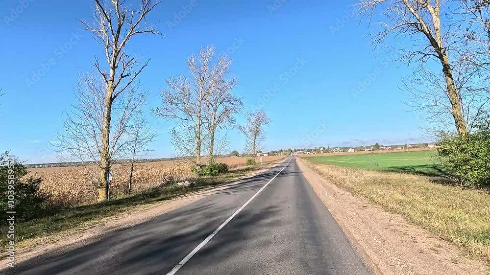 Autumn landscape and view of the road in motion. Driving a car on the road at speed. Asphalt and white road markings.