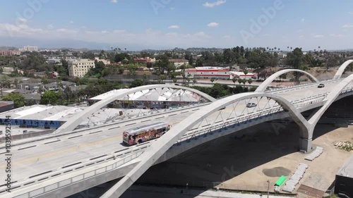 Aerial tracking public bus on the famous 6th street bridge out of downtown Los Angeles during the day time photo