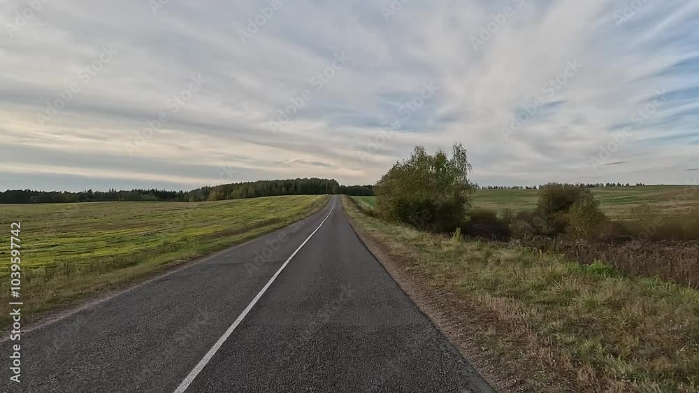 Autumn landscape and view of the road in motion. Driving a car on the road at speed. Asphalt and white road markings. Autumn landscape and view of the road in motion. Driving a car on the road at speed. Asphalt and white road markings.