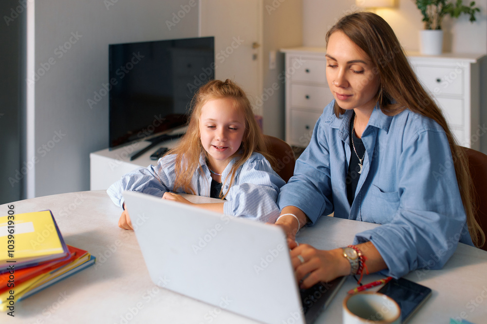 Young schoolgirl and her mother doing homework for a school lesson Young schoolgirl and her mother doing homework for a school lesson