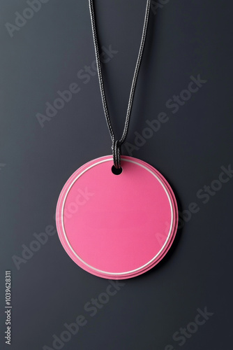 A bright pink circular tag hangs from a string on a black surface, adding vibrant detail during a bustling shopping event, perfect for promotions