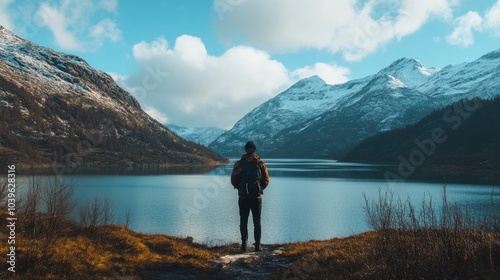 Travel blogger admiring breathtaking mountain and lake landscape with vibrant reflections, capturing the serenity of nature in a stunning outdoor adventure setting


