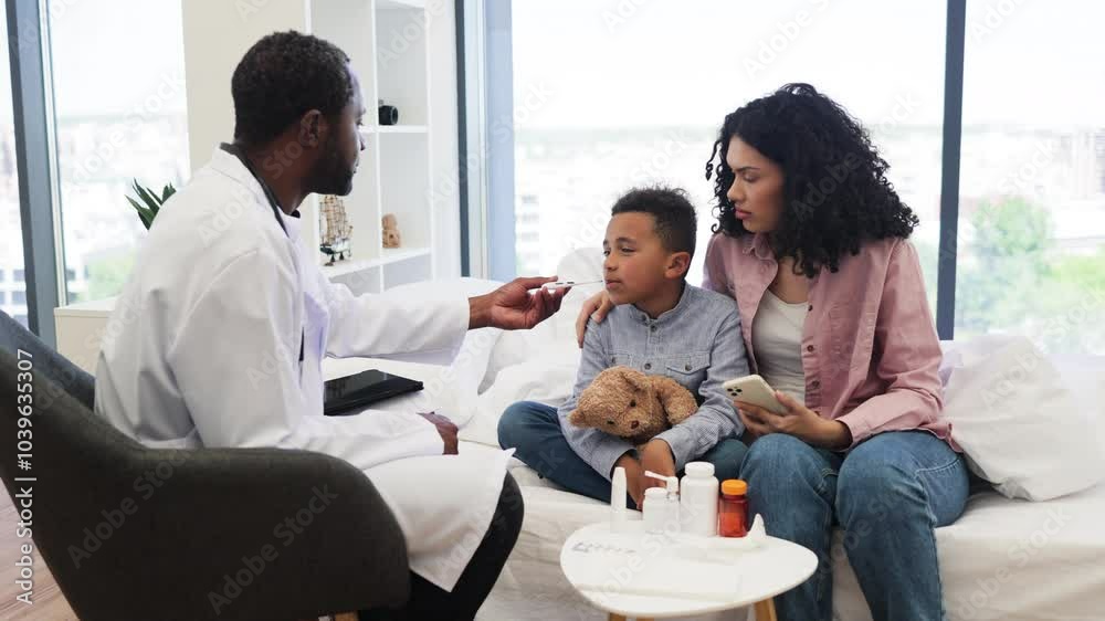 Male doctor in modern office taking temperature of African boy seated with mother. Boy appears sick, holding teddy bear for comfort. Male doctor in modern office taking temperature of African boy seated with mother. Boy appears sick, holding teddy bear for comfort.