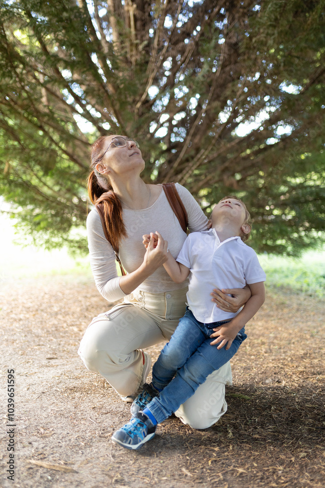 A woman and a child are sitting in a park A woman and a child are sitting in a park