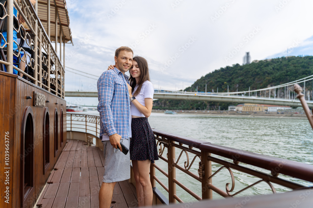 Couple in love standing on yacht deck while sailing in the sea. Handsome man and beautiful woman having romantic date Couple in love standing on yacht deck while sailing in the sea. Handsome man and beautiful woman having romantic date