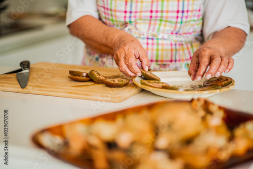 Elderly person slicing and arranging tomatoes in the kitchen