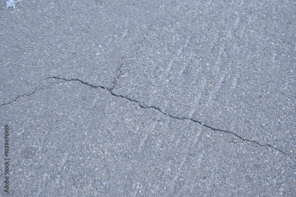 Obraz premium Cracks on grey asphalt close-up, old cracked asphalt close-up, old road surface bitumen 