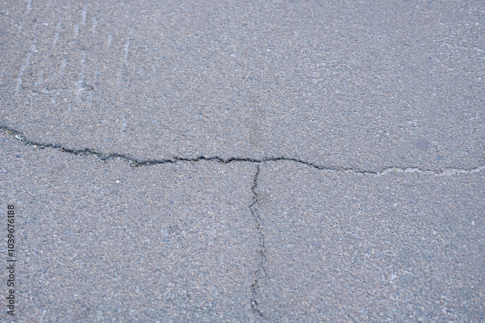 Obraz premium Cracks on grey asphalt close-up, old cracked asphalt close-up, old road surface bitumen 