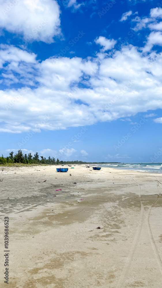 A serene, deserted beach with scattered fishing boats under a partly cloudy sky, perfect for promoting relaxation and eco-tourism A serene, deserted beach with scattered fishing boats under a partly cloudy sky, perfect for promoting relaxation and eco-tourism