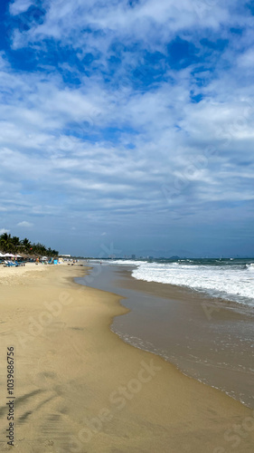 Scenic view of a sunny tropical beach with gentle waves and palm trees, perfect for summer vacation and relaxation