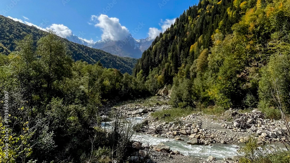 A scenic mountain landscape with a flowing river and lush forest under a bright blue sky, symbolizing tranquility and nature conservation A scenic mountain landscape with a flowing river and lush forest under a bright blue sky, symbolizing tranquility and nature conservation
