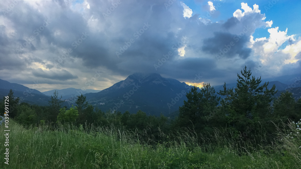Fototapeta premium Dramatic storm clouds gather over a lush mountain landscape, evoking concepts of weather unpredictability and natural beauty