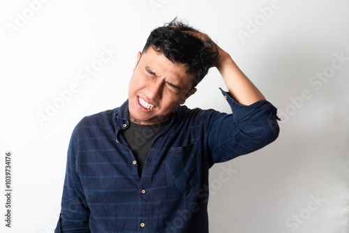 Asian man showing stress expression with his hand grabbing hair