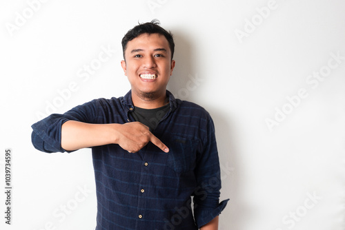 Adult Asian man smiling happy while pointing down photo