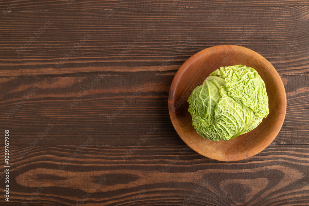 Green lettuce on plate on brown wooden. Top view, copy space Green lettuce on plate on brown wooden. Top view, copy space