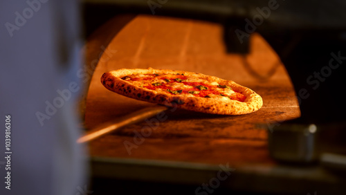 A pizza is baking on a stone in a traditional brick oven, surrounded by flames photo