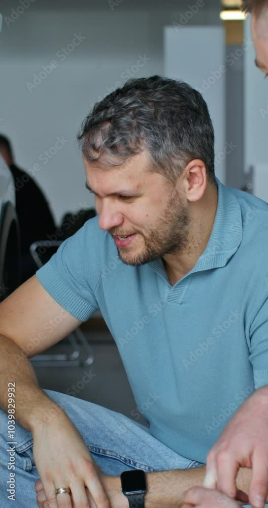 The car dealership manager is talking to the customer standing next to the car. Choosing a car in the showroom The car dealership manager is talking to the customer standing next to the car. Choosing a car in the showroom