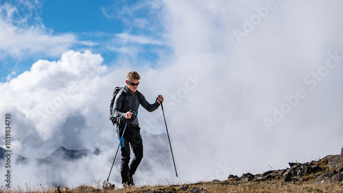 A man hiking in the Alps in between clouds