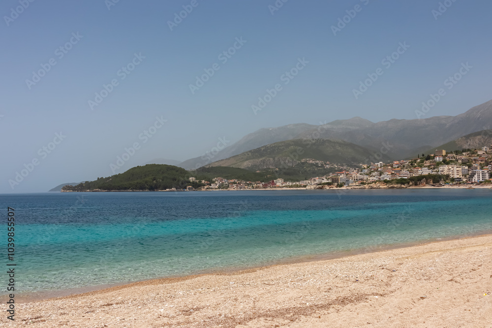 Panoramic view of the picturesque coastline of coastal tourist town Himare, Vlore, Albania. Sand beach Potami with scenic vistas of majestic mountains of Karaburun-Sazan Marine Park. Summer vacation Panoramic view of the picturesque coastline of coastal tourist town Himare, Vlore, Albania. Sand beach Potami with scenic vistas of majestic mountains of Karaburun-Sazan Marine Park. Summer vacation