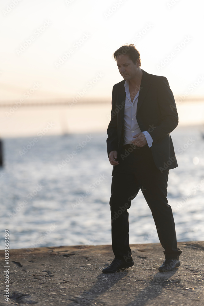 Businessman walking on pier at sunset Businessman walking on pier at sunset