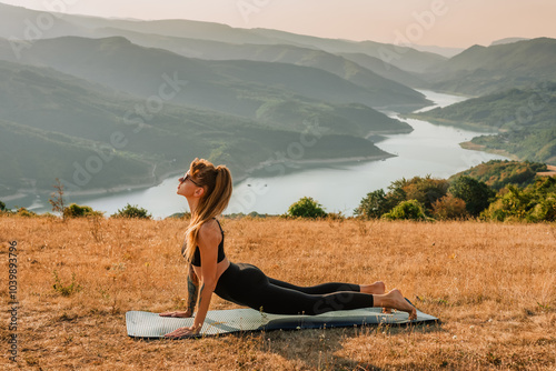 Obraz na płótnie Young Woman Practicing Yoga Outdoors in Mountains w salonie
