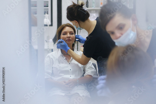 Obraz na płótnie Middle aged woman getting makeup done in beauty salon w salonie