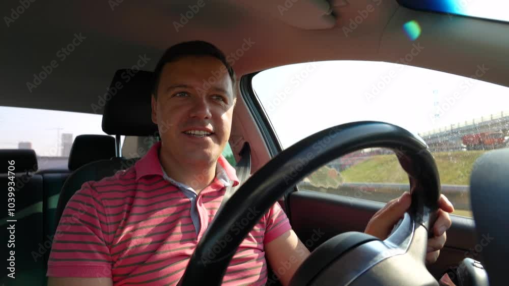 A man in a car waves at the camera while navigating through busy city traffic in the late afternoon light A man in a car waves at the camera while navigating through busy city traffic in the late afternoon light