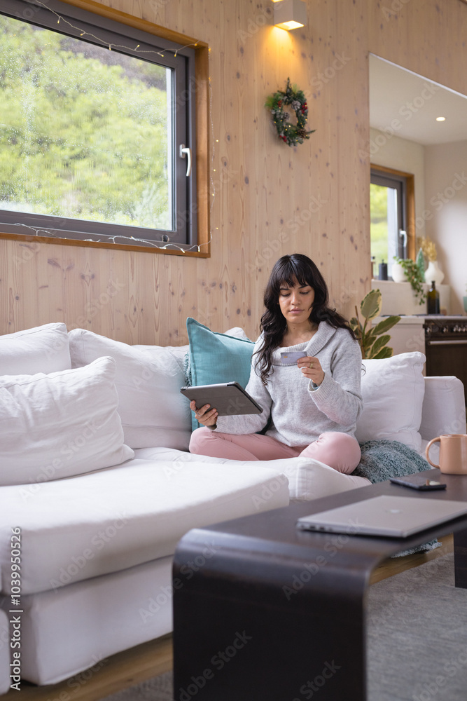 Christmas time, woman relaxing at home, using tablet and enjoying coffee on cozy sofa Christmas time, woman relaxing at home, using tablet and enjoying coffee on cozy sofa