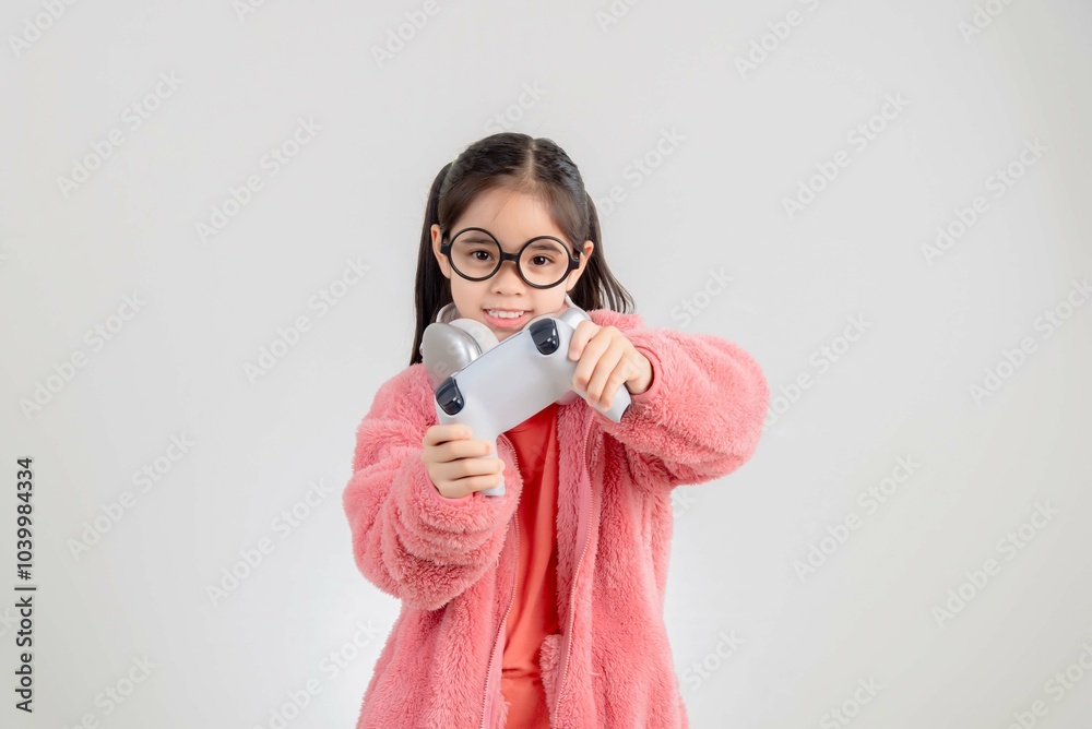 Fototapeta premium Asian happy portrait young kid girl smile lifestyle games technology holding joystick game playing on hands studio shot isolated white background with copy space.