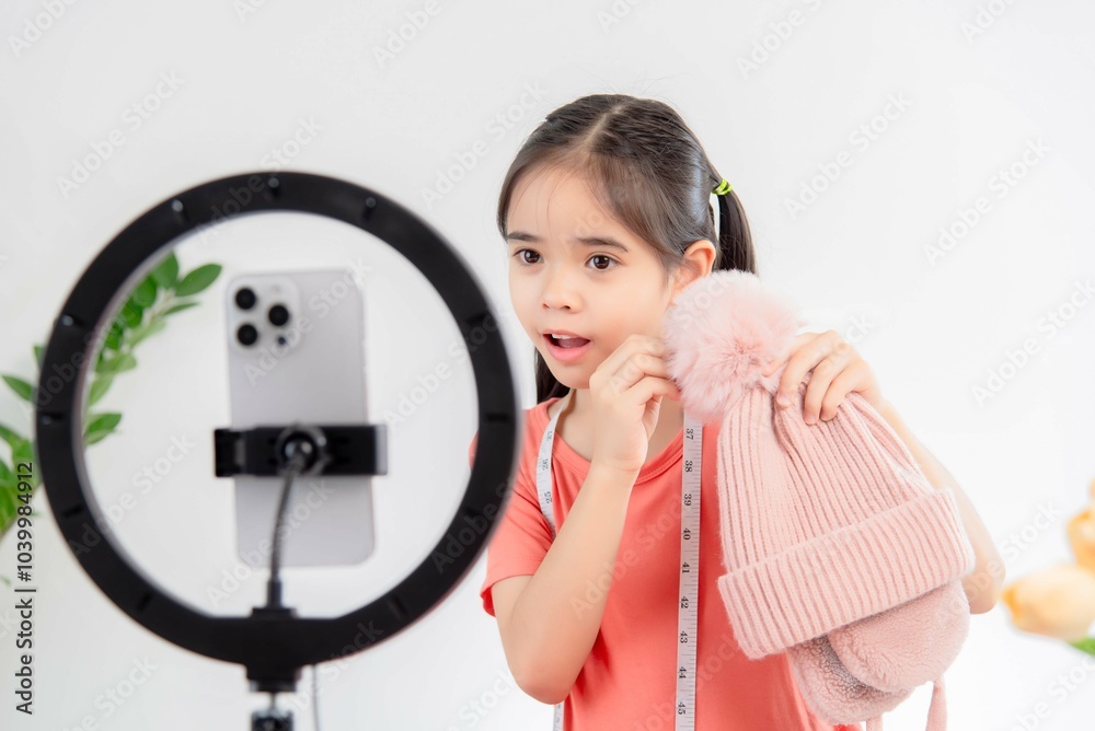social media market concept. Asian cute girl seller showing clothes during live streaming in the mobile application. social media market concept. Asian cute girl seller showing clothes during live streaming in the mobile application.