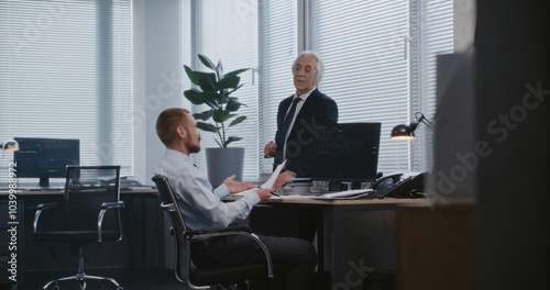 In modern office: Discussion between head of analytical department and manager about financial strategy. Personal computer screen shows equity and shares market. International stock exchange company.