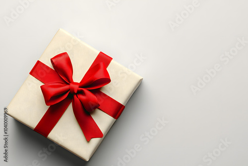 Gift box with red bow on light grey background, top view. Space for text