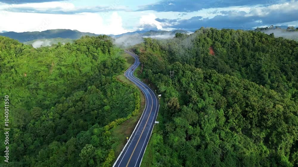 Aerial view of a beautiful road surrounded by pristine forest. The pristine forest of Nan Province, Thailand. Aerial view of a beautiful road surrounded by pristine forest. The pristine forest of Nan Province, Thailand.