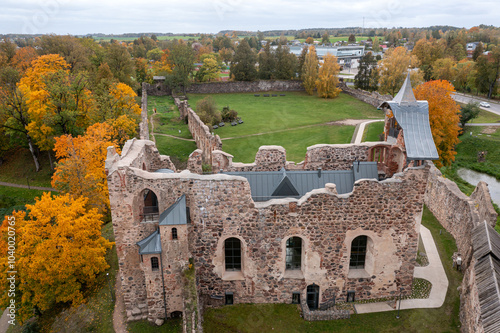 Ruins of a historical castle surrounded by colorful autumn trees in a serene landscape photo