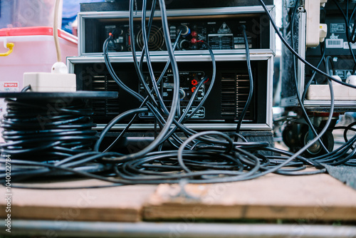 An audio mixer with various knobs, sliders, and connected cables photo