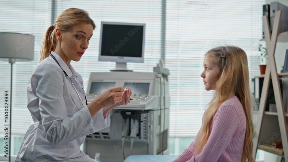 Obraz premium Smiling pediatrician giving high five to cute girl. Closeup child visit doctor