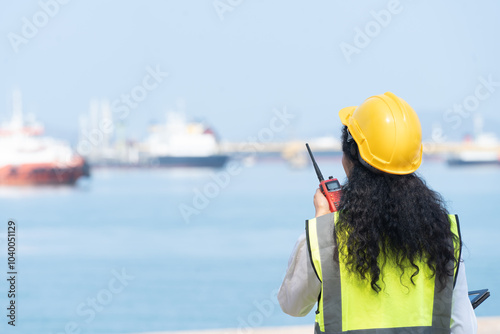 Asian Female Engineer Holding Walkie-Talkie with Marine Ship Background