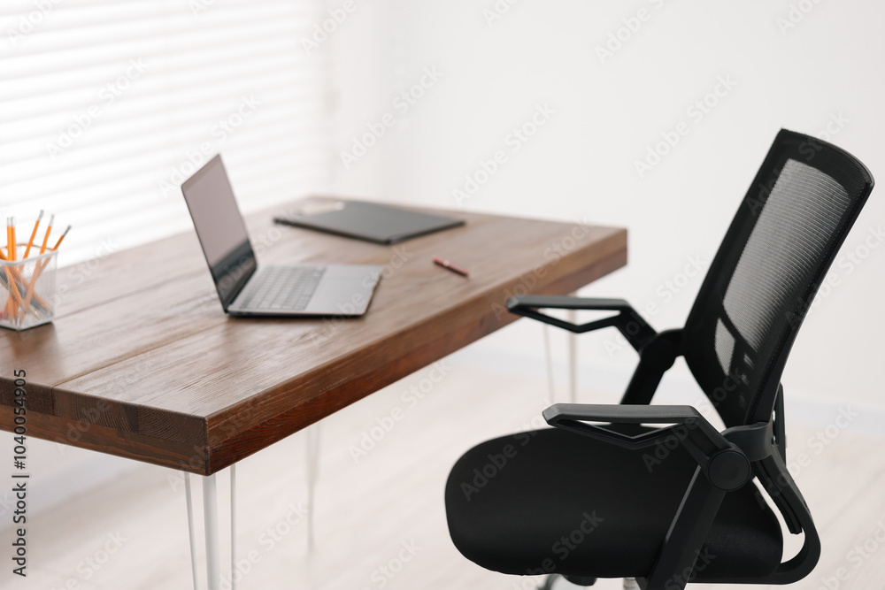 Black chair, laptop and desk in office, closeup Black chair, laptop and desk in office, closeup