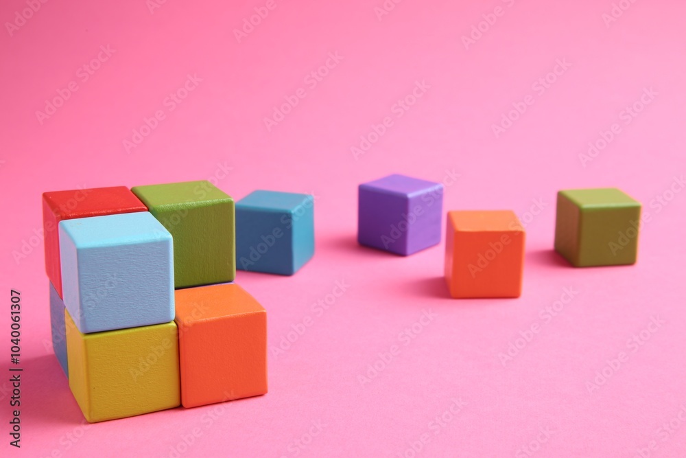 Many wooden colorful cubes on pink background Many wooden colorful cubes on pink background