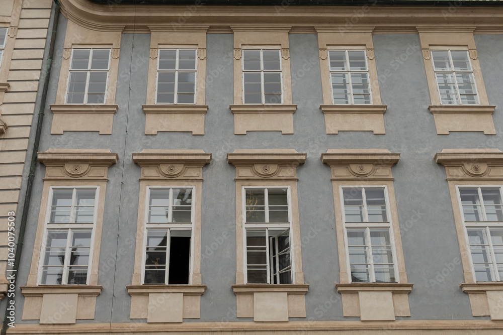 The charming blue facade with intricately designed windows showcases classic architecture delightfully The charming blue facade with intricately designed windows showcases classic architecture delightfully